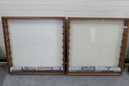 Two wall mounted glass fronted wooden display cabinets with glass shelves.