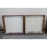 Two wall mounted glass fronted wooden display cabinets with glass shelves.