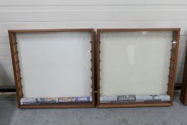 Two wall mounted glass fronted wooden display cabinets with glass shelves.