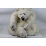 Soft Sensations bear by PMS International - A large plush white bear in sleeping position with what