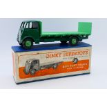 Dinky - A boxed Guy Flat Truck with tailboard in dark green with light green wheels and back # 513.