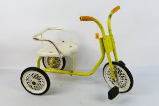 A vintage children's tricycle in yellow and white, with age and play signs appearing Fair overall,