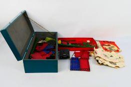 Meccano - A wooden box of vintage Meccano parts in red, blue and green, with wheels,