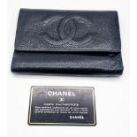 A Classic Vintage Chanel Black Leather Wallet with Authentication Card. Chanel motif on front.