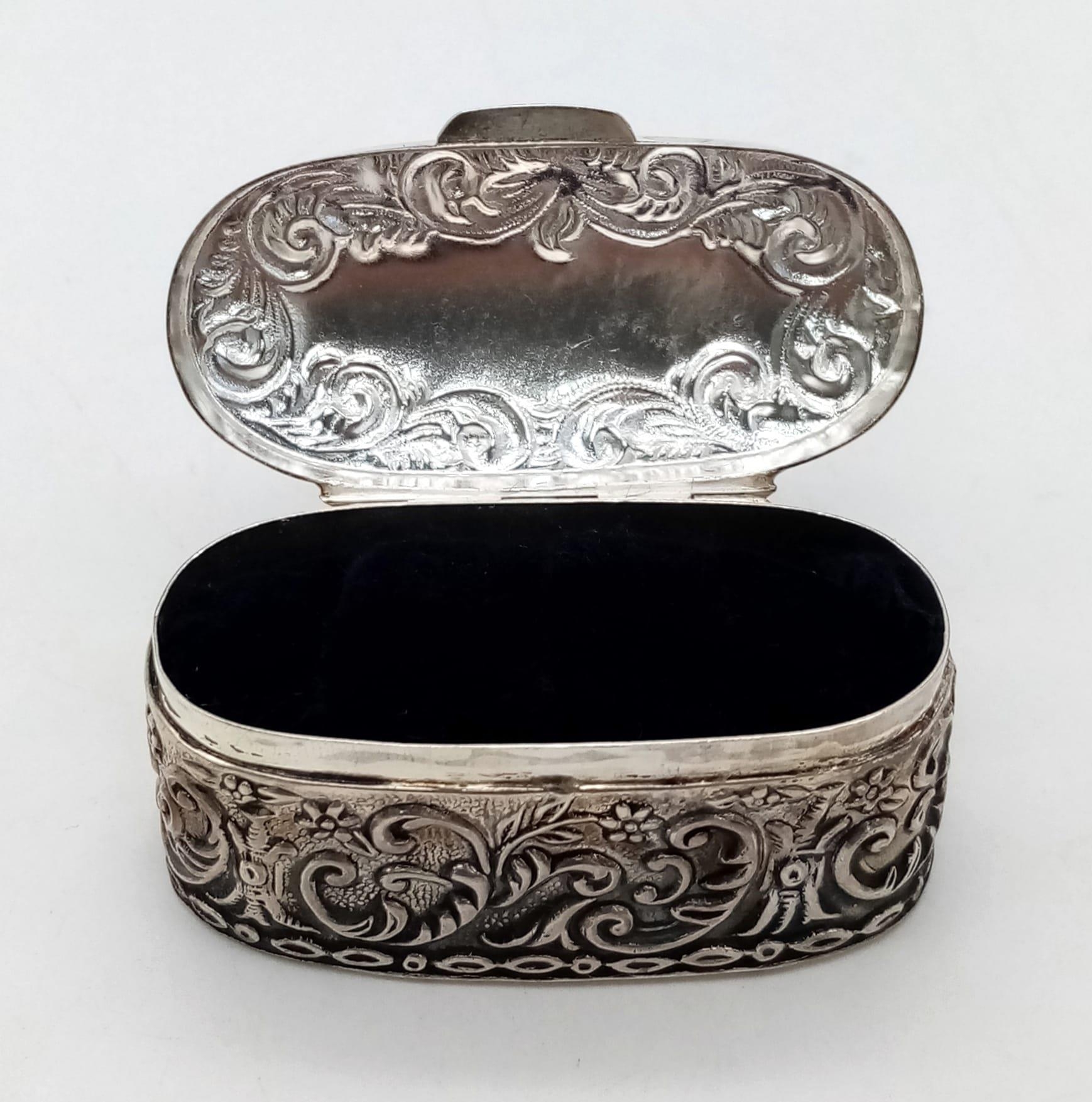 An Antique Silver Oval Trinket Box with Scrolled Decoration. 28g. 5 x 2.5cm.