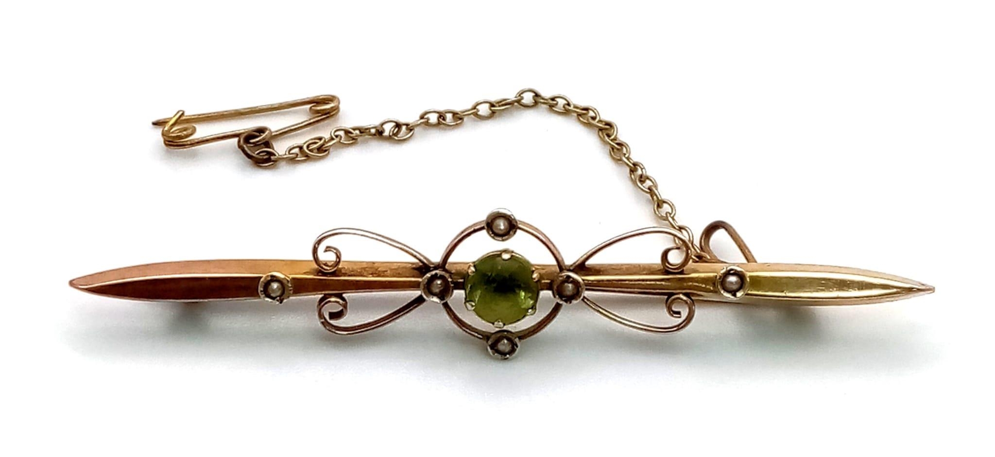 An Antique 9K Yellow Gold Peridot and Seed Pearl Bar Brooch. With safety chain. 6.5cm length. 3.1g