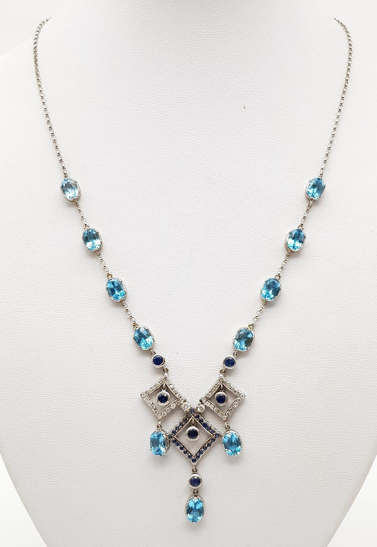 An Elegant 18K White Gold Necklace - interspersed with clean aquamarine stones and climaxing in a