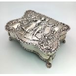 An Antique Silver Trinket Box. A romantic repoussé scene on lid. Four claw feet. A lovely piece in