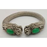 A Tibetan Silver Twin Dragon Twisted Bangle/Bracelet with Green Jade head decoration. 7cm inner