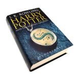 A hardback first edition of Harry Potter and the deathly hallows with adult dust cover.