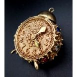 A 9K GOLD CLOCK PENDANT OR CHARM DECORATED WITH GEMSTONES . 12gms