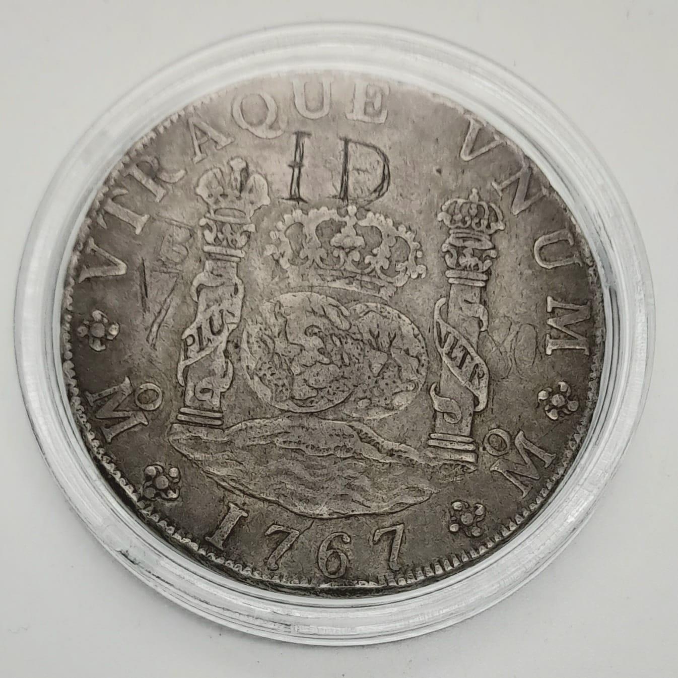 A Silver 1767 Mexican Pillar Dollar Coin with Graffiti. Please see photos for overall conditions.