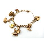 A 9K Yellow Gold Vintage Charm Bracelet with Heart Clasp. Six eclectic charms. 18cm. 23.42g total