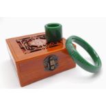 A wonderful Chinese, green jade set of a bangle and a thumb ring, finely engraved with Buddhist