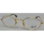 A gold tone RAY-BAN pair of glasses with original case and cleaning cloth.