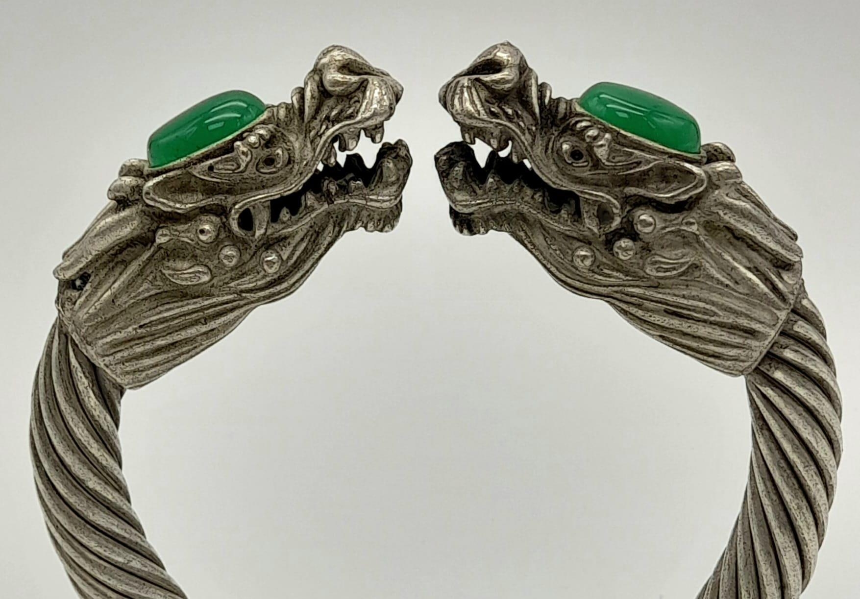 A Tibetan Silver Twin Dragon Twisted Bangle/Bracelet with Green Jade head decoration. 7cm inner - Image 2 of 3