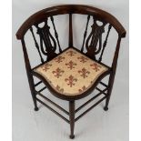 A VICTORIAN CORNER CHAIR TASTEFULLY REUPHOLSTERED WITH CURVED BACK REST ON HARP SHAPED STRUTTS.