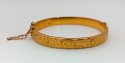 A Vintage 9K Yellow Gold Bangle. Clip opening with safety chain. Scrolled decoration. 6cm inner