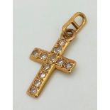 An 18 K yellow gold diamond (0.35 carats) cross. Weight: 1 g.