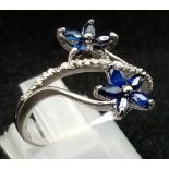 An 18K White Gold Diamond and Sapphire Floral Burst Ring. 3.35g total weight. Size M/N.