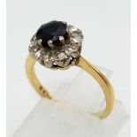 An 18 K yellow gold ring with a diamond and sapphire cluster. Ring size: K, weight: 3.4 g.