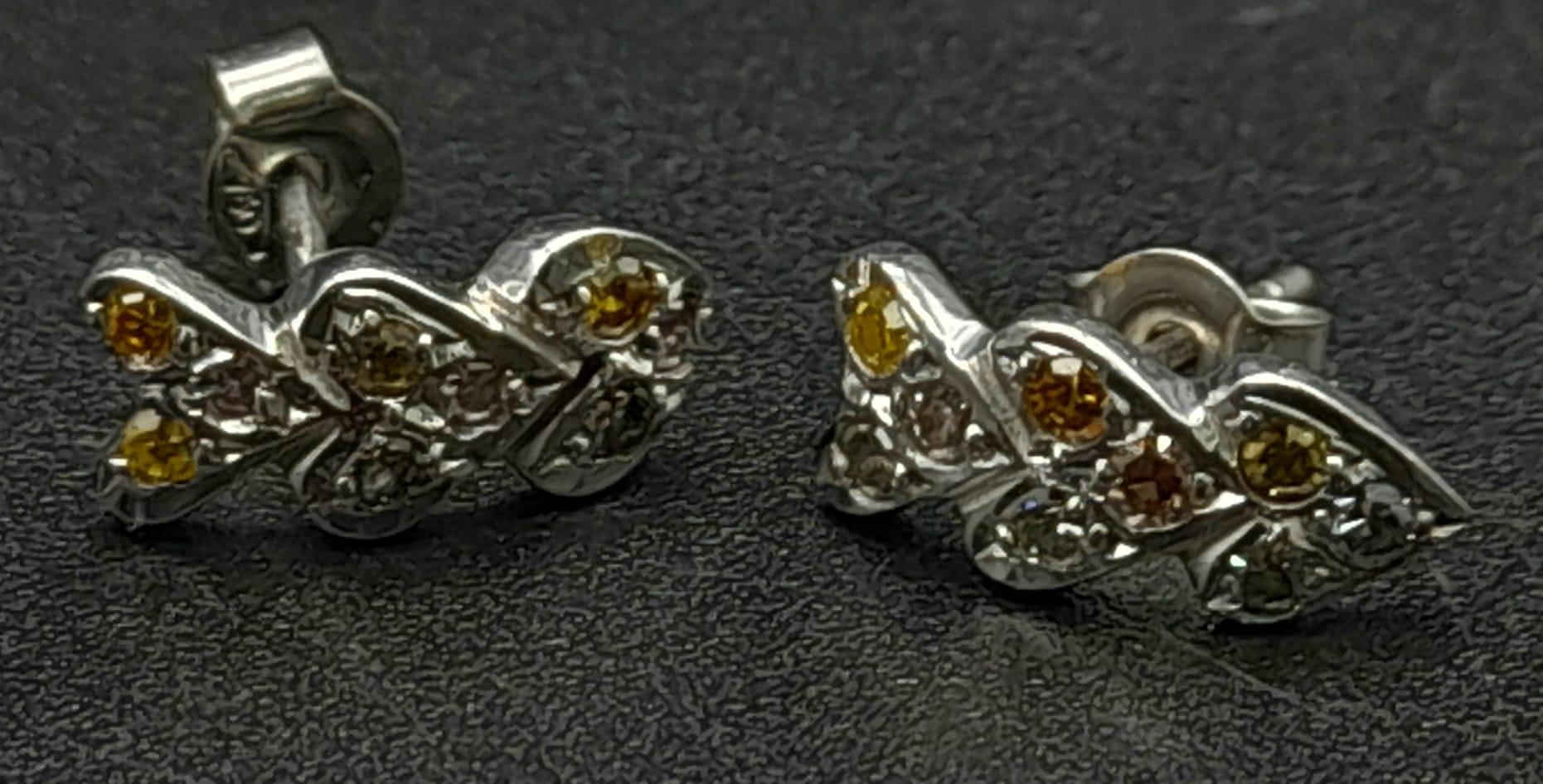 A Pair of fancy natural multi-coloured diamond stud earrings set in 18K white gold. Ref:15