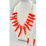 A statement necklace and earrings set with genuine red corals and natural, cultured white pearls.