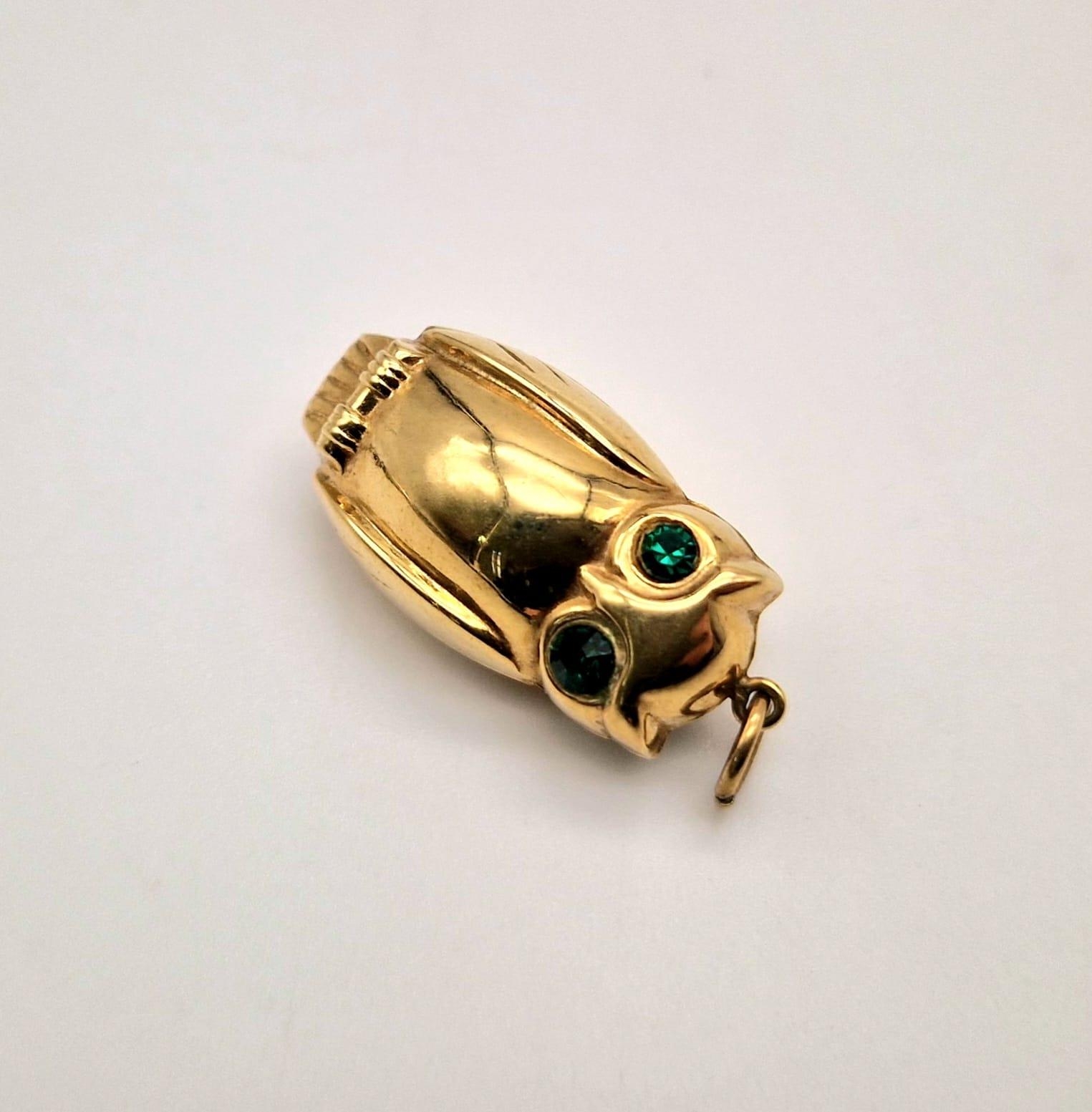 a 9 K yellow gold owl charm/pendant with green stone set eyes, weight: 1.6 g.