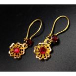 A Pair of 9K Yellow Gold Garnet Earrings. Set in a floral decoration. 1.15g total weight.
