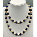 A Delightful Lapis Lazuli and Cultured Pearl Matinee Necklace. 70cm. Gilded spacers and clasp.