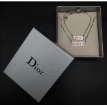 A Christain Dior White Metal Tag Necklace and Bracelet. Both adjustable. Excellent condition.