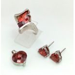 A sterling silver lot with red cubic zirconia including a pair of heart shaped earrings, a heart