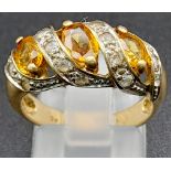 A Vintage 9K Yellow Gold Citrine and Diamond Ring. Three diagonal waves of bright citrine