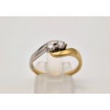 An 18 K two colour gold twist ring with two diamonds ( 0.25 carats). Ring size: O, weight: 3.4 g.