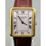 A Classic Patek Philippe 18k Gold Ladies Watch. Burgundy leather strap. 18k gold case - 22 x 25mm.