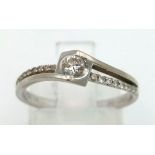 18K WHITE GOLD DIAMOND SOLITAIRE RING WITH TWIST DIAMOND SHOULDERS. 0.18CT DIAMOND. WEIGHS 2.2G.