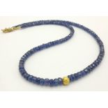 A 99ct single strand Blue Sapphire Necklace with a gilded bead and 18K gold plated clasp. Length: