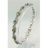 A Mystic Topaz Tennis Bracelet. Spare link attached. Set in white metal. 19cm