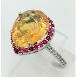 An 18K white gold ring with a pear cut fire opal surrounded by rubies and diamonds on the