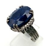 A 20.30ct Oval cut Natural Blue Sapphire Ring set in 925 silver, decorated with 0.20ct Diamond