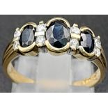 A 9K Yellow Gold Three Stone Sapphire with Diamonds Ring. Three oval cut sapphires separated with