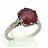 An 18K White Gold, Ruby and Diamond Ring. A 3.3ct round ruby with six brilliant round cut diamonds