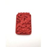 A Hand-Carved Cinnabar Dragon Rectangular Pendant. 6cm