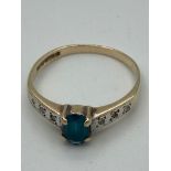 9 carat YELLOW GOLD RING with oval AQUA set to top,having WHITE GOLD shoulders with diamond