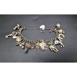 A Vintage 925 Silver Charm Bracelet with a Heart Clasp. Over 20 mesmerizing charms. 20cm. 69g