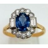 An 18K yellow gold ring with a blue, oval cut sapphire, surrounded by round and baguette cut