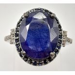 A 7.50ct Blue Sapphire Gemstone Ring with 0.30ct diamond wings and 0.60ct blue sapphire surround.