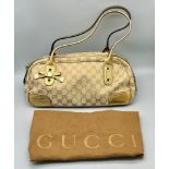 A Gucci Canvas Princy Shoulder Bag. A canvas body with gilded leather trim. Interior zipped