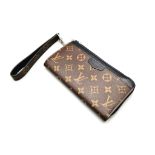A Louis Vuitton Clutch Wallet with Handle. Brown monogram canvas. Silver-tone hardware. Zipped