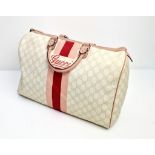 A Gucci Boston Bag. Monogram canvas in a light beige hue. Pink leather trim and handles. Gilded